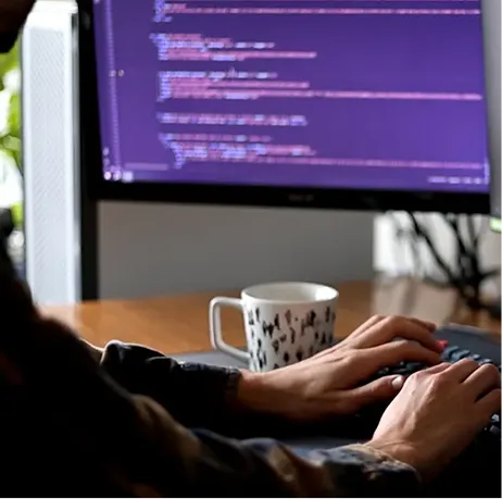 Hands typing code on a keyboard